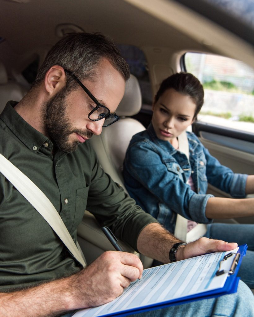 teacher-writing-something-to-clipboard-during-driving-test.jpg